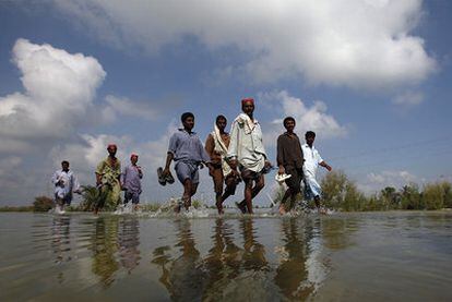 Un grupo de afectados por las lluvias regresa a sus localidades en Karampur, en la provincia de Sindh, al sur del país.