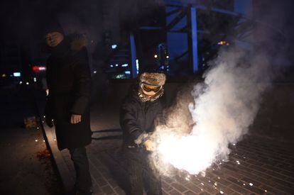 Un padre controla cómo su hijo enciende una bengala en Pekín (China) durante la celebración del Año Nuevo Chino, el 7 de febrero de 2016.