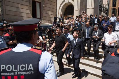 El jugador del FC Barcelona Lionel Messi (c) y su padre, Jorge Horacio Messi (detrás), sale de la Audiencia de Barcelona tras declarar en la tercera jornada del juicio.
