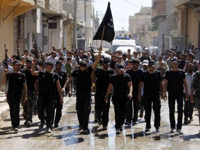 Un grupo de combatientes islamistas ondea su bandera en el funeral por un compa&ntilde;ero ca&iacute;do ayer cerca de Alepo.