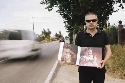 Antonio Ángel Pertusa sostiene una foto de su hija en el lugar donde fue atropellada, en el municipio alicantino de Almoradí.