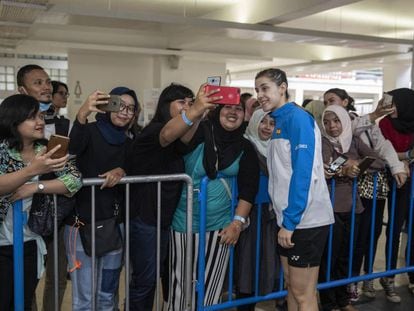 Carolina Marín se hace fotos con un grupo de aficionados a la salida del pabellón de Yakarta tras un partido del masters.