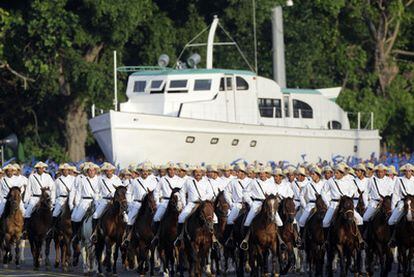 Desfile de caballería ante una réplica del yate <i>Granma</i> durante la parada de ayer.