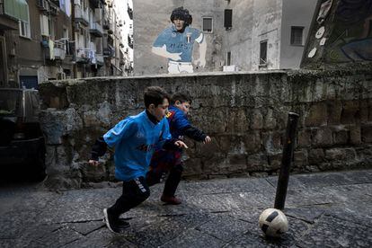 Two children, wearing Maradona and Messi shirts, play in the Neapolitan neighborhood of Forcella.