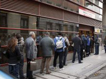 Una fila de personas hace cola en una oficina del INEM en Madrid.