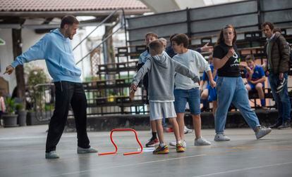Álex Remiro juega junto a dos niños del taller, que imitan su gesto.