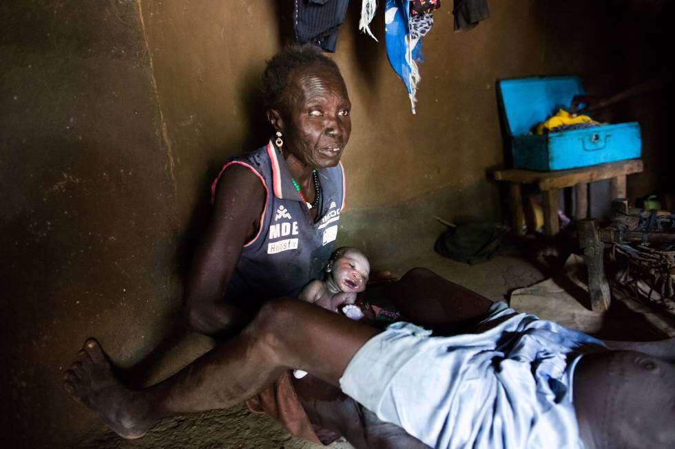 La anciana partera Welge Konya sostiene a un varón fuerte y sano que Bai acaba de dar a luz en su cabaña de Dangaji, en Sudán del Sur.