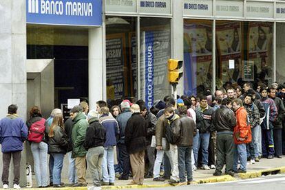 Argentinos hacen cola para retirar su dinero de un banco durante la crisis financiera de 2002.