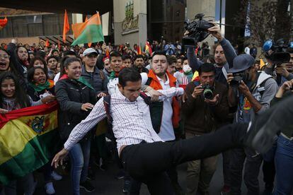 Un manifestante opositor amaga con patear a un simpatizante de Evo Morales el lunes, en La Paz.
