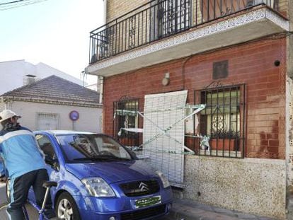 Un vecino observa la vivienda precintada de la calle Tarragona de Armilla (Granada) tras el asesinato de un hombre.