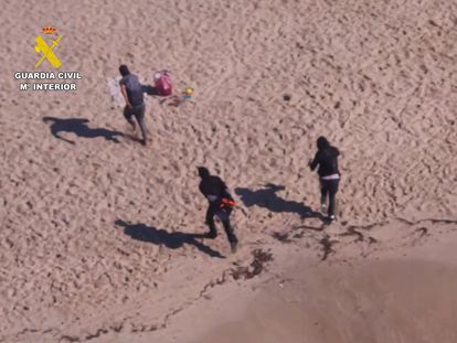 Momento en el que los tres presuntos ocupantes de la narcolancha emprenden la huida tras dejar la embarcación en la playa de Cala Gran, en el municipio de Santanyí.