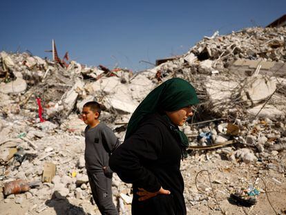 Fatmagul Arslan, 19-year-old, and her brother Saltuk, 9-year-old, stand as they visit the remains of their home, where they were trapped for five days with their parents and sister until being rescued, in the aftermath of a deadly earthquake in Nurdagi, Turkey, March 4, 2023. REUTERS/Susana Vera