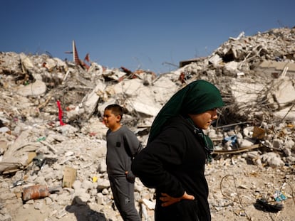 Fatmagul Arslan, 19-year-old, and her brother Saltuk, 9-year-old, stand as they visit the remains of their home, where they were trapped for five days with their parents and sister until being rescued, in the aftermath of a deadly earthquake in Nurdagi, Turkey, March 4, 2023. REUTERS/Susana Vera