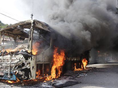 Un autob&uacute;s incendiado en la favela de Caramujo.