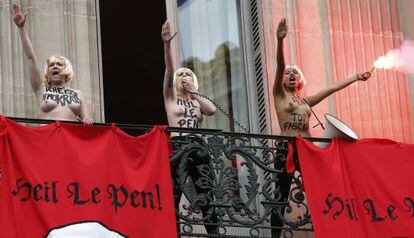 Tres activistas de Femen, que tratan de boicotear un acto del Frente Nacional francés, exhiben la frase "Heil Le Pen".