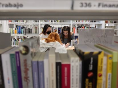 Tres jóvenes estudian en la biblioteca pública municipal del barrio de San Fermín, en Madrid, recientemente inaugurada.