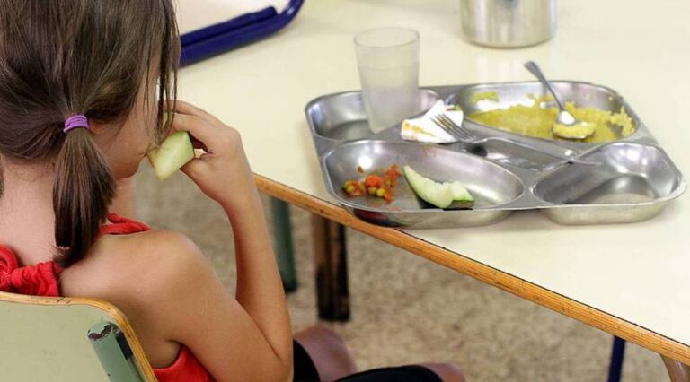 Una niña almuerza en un comedor escolar.