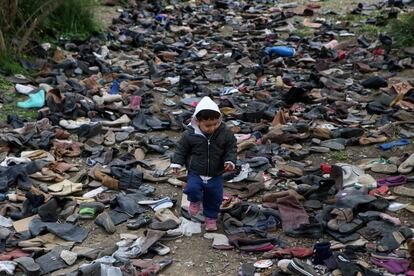 Un niño corretea entre calzado desechado, en el campamento de Moria.