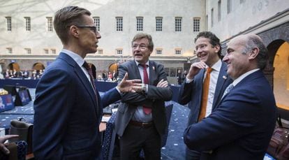 El ministro de Economía, Luis de Guindos, y el presidente del Eurogrupo, Jeroen Dijsselbloem, charlan con el ministro belga de Finanzas, John Robert Overtveldt, y el ministro finlandés de Finanzas, Alexander Stubb