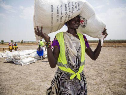 Una voluntaria traslada un saco de semillas en un campo de refugiados en Uganda.  