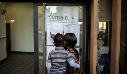 Una mujer busca información sobre la nueva clase de su hijo, en una escuela maternal en Lyon (Francia), en 2014.
