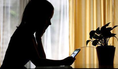 Una mujer consulta su teléfono móvil.