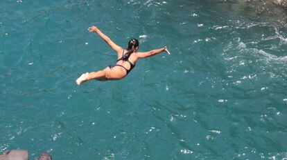 Una chica salta en Acapulco durante la celebraci&oacute;n de una tradici&oacute;n que es atractivo tur&iacute;stico en la costa mexicana.