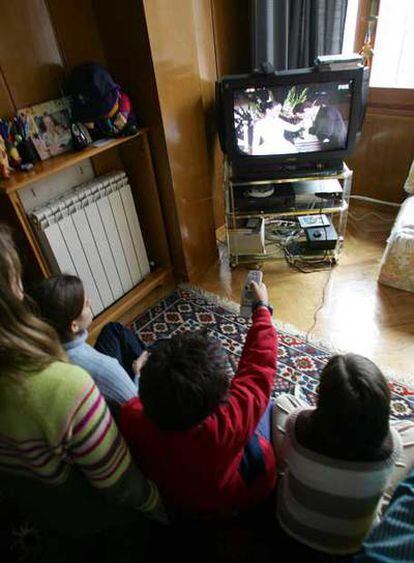 Un grupo de niños ve la televisión en su domicilio.