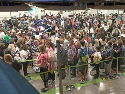 Decenas de personas esta mañana haciendo cola ante el control de pasaportes en el aeropuerto de Madrid-Barajas.