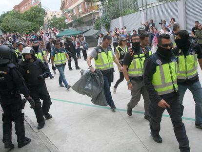 Agentes de la policía nacional retiran urnas del IES Tarragona, el 1 de octubre.