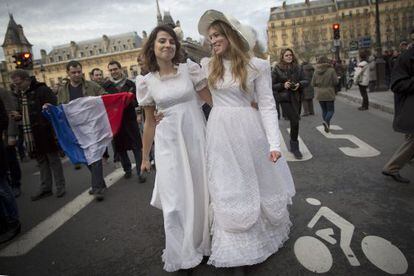 Dos mujeres con traje de novia durante una manifestación a favor de la legalización del matrimonio igualitario en París. 