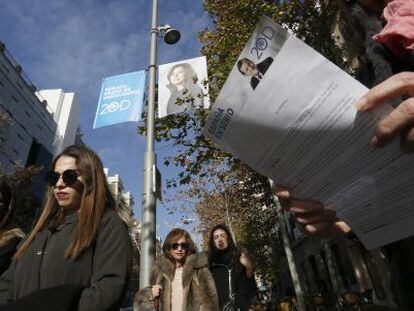 Una mujer lee una informaci&oacute;n electoral de Rajoy en el Barrio Salamanca.