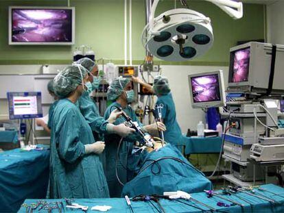 Intervención laparoscópica en la que el cirujano opera a través de pequeñas incisiones y observa sus movimientos en varias pantallas.