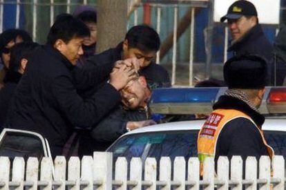 Un partidario de Liu Xiaobo es introducido en un coche policial tras manifestarse ante el tribunal.