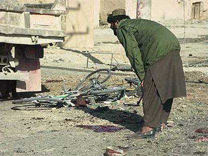 Un soldado afgano observa el lugar en el que ayer explotó una bomba en Kandahar.