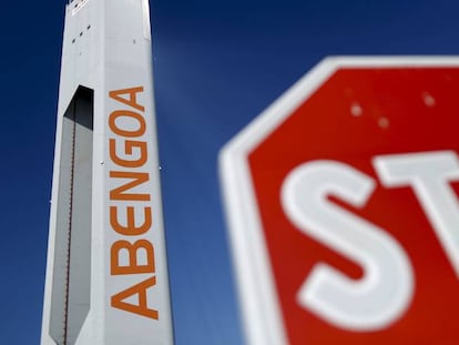 Una torre de una planta solar de Abengoa, al lado de una señal de stop. 