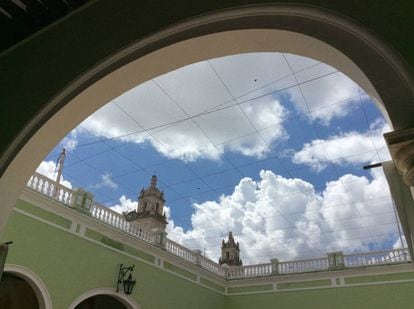 Las torres de la catedral de San Ildefonso, en Mérida, asoman a través de un edificio colonial.