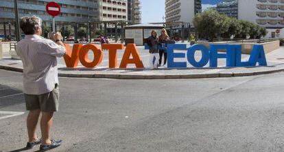 Unos vecinos se fotografían junto a las letras colocadas por el PP en Cádiz.