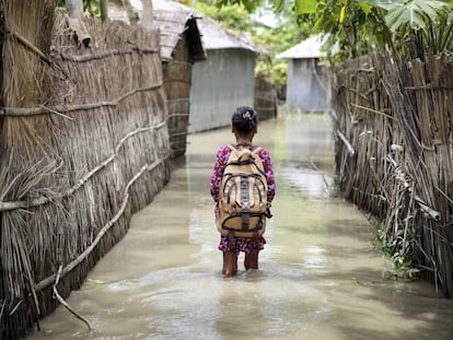 Una niña va al cole en su aldea inundada por lluvias torrenciales en Kurigram (Bangladés).