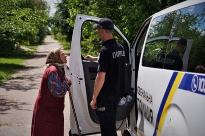 Ana, 92, approaches the mobile police patrol in Lukianivka, in the kyiv region