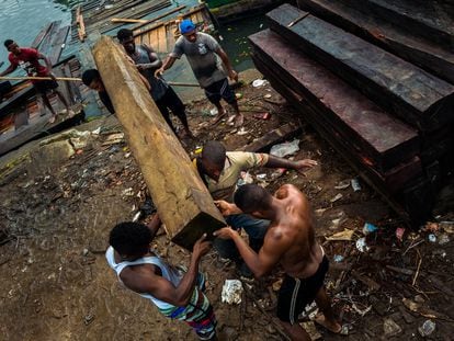 Trabajadores afrocolombianos cargan madera aserrada para ser exportada, en Turbo (Colombia), el 3 de diciembre de 2019.