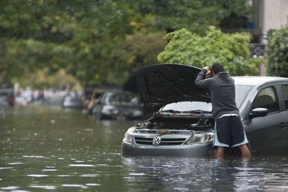 Un hombre permanece junto a su coche en una calle inundada en Buenos Aires (Argentina), 2 de abril de 2013.