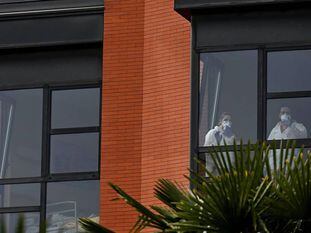 Dos trabajadoras miran por la ventana desde el interior de la residencia de ancianos Monte Hermoso, este miércoles, en Madrid. En vídeo, aumenta el número de contagios en las residencias de ancianos.