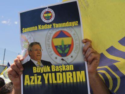 Un seguidor del Fenerbahçe muestra un cartel con una foto de Yilidrim en que se lee “Gran presidente, estaremos juntos hasta el final”.