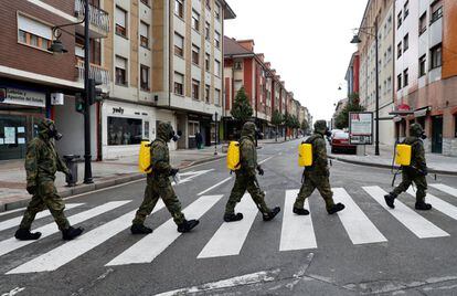  El Ejército de Tierra, desplegado ya en los últimos días en varias localidades asturianas para apoyar a las Fuerzas y Cuerpos de Seguridad en el control del cumplimiento de las medidas establecidas por el decreto de estado de alarma por la pandemia del coronavirus, durante las labores de desinfección este jueves en Lugones (Siero). 