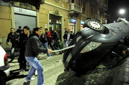 Un joven golpea un coche durante los disturbios desatados en Milán tras el asesinato de un joven egipcio.