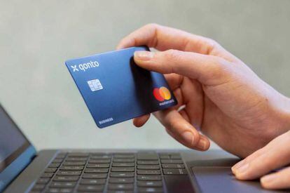 Una persona haciendo un pago online con una tarjeta de Qonto