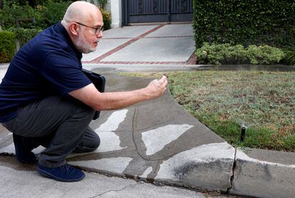 Damon Ayala, one of the water police officers who have been deployed to Los Angeles, photographs one of the irrigation sprinkler heads.