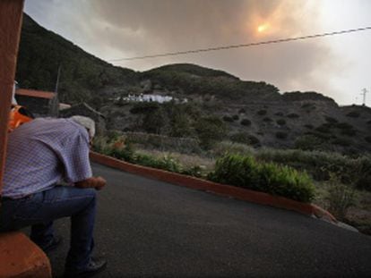 Un vecino observa el humo procedente del incendio que afecta al parque nacional del Garajonay, en La Gomera.