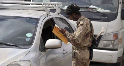 Un soldado yemen&iacute; inspecciona la documentaci&oacute;n en un puesto de control.